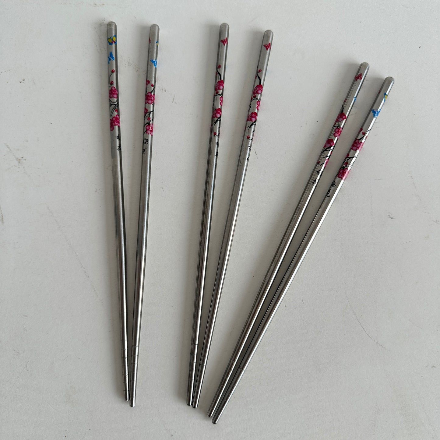 TT100 THREE PAIRS OF SILVER CHOPSTICKS WITH PINK FLOWERS AND BUTTERFLIES
