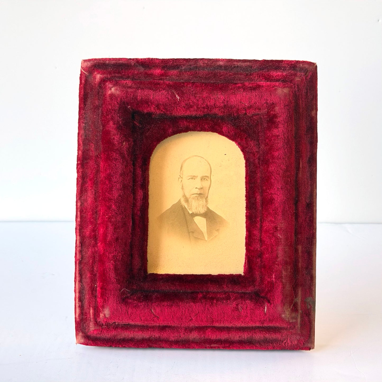 WD022 DISTRESSED RED VELVET UPHOLSTERED FRAMED PORTRAIT OF BEARDED MAN